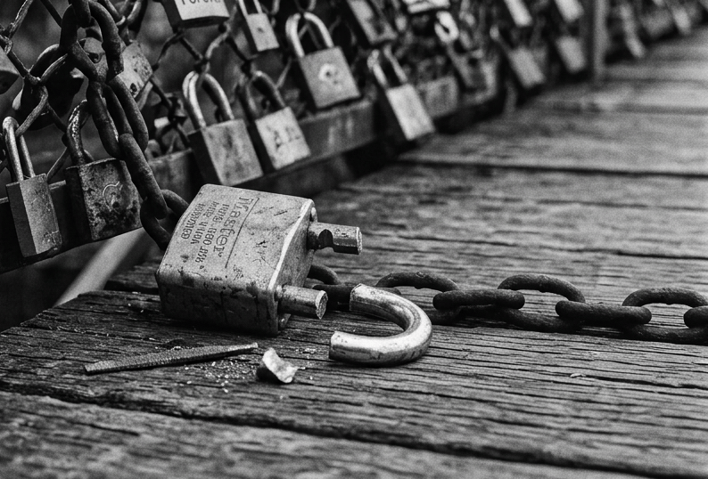 Weathered padlock and chain on a wooden workbench