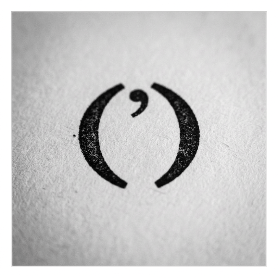 Black semicolon symbol printed on white textured paper